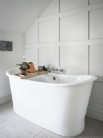 Baignoire sur pied blanche dans une salle de bains blanche classique