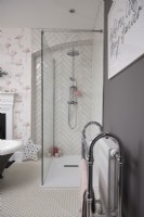 Salle de bain avec cabine de douche à l'italienne, carrelage à chevrons et papier peint flamant rose.