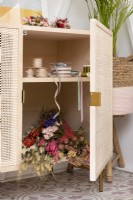 Armoire artisanale en bois sur pied avec portes en rotin pour ranger rubans et fleurs séchées