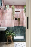 Salle de douche carrelée rose et verte avec porte escamotable coulissante