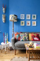 Canapé gris avec coussins dans un salon bleu coloré