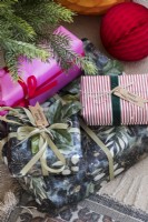 Détail de cadeaux de Noël emballés de couleurs vives sous l'arbre