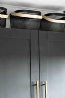 Détail de la cuisine - paniers noirs sur le dessus des armoires de cuisine