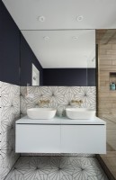 Murs et sols à motifs dans une salle de bains moderne avec double vasque