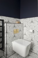 Toilettes blanches dans une salle de bains moderne avec carreaux de sol et de mur à motifs