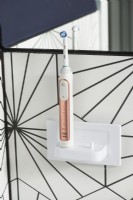 Détail de la brosse à dents électrique sur le support dans la salle de bains moderne