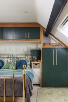 Armoires intégrées dans une chambre moderne avec lit en laiton