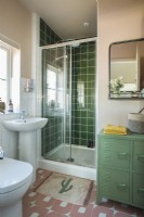 Salle de bain moderne avec carrelage vert dans la cabine de douche