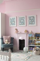 Murs peints en rose et cheminée dans la chambre des enfants