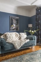 Œuvres d'art modernes sur le mur du salon avec des murs peints en bleu divisés