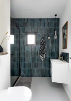 Salle de bain blanche contemporaine avec mur gris carrelé