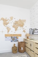 Coin d'une chambre d'enfant avec rangements en pin et mappemonde murale en bois