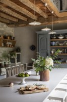 Îlot moderne dans une cuisine de campagne rustique avec poutres apparentes