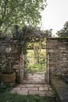 Mur de pierre et portail dans le jardin de campagne