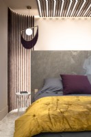 Tête de lit en marbre et éclairage contemporain dans une chambre moderne