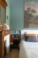 Peinture vintage sur mur peint en bleu sarcelle dans une chambre de campagne