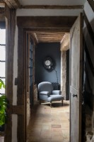 Chaise grise antique dans le couloir de pays avec sol carrelé en pierre