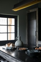 Îlot dans une cuisine de campagne rustique et moderne avec des armoires peintes en noir