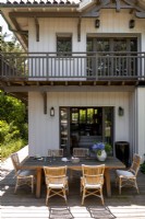 Grande table à manger extérieure sur terrasse de maison de campagne en bois