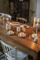 Détail de la salle à manger de campagne avec des tasses à café et des bougies allumées