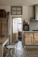 Cuisine-salle à manger de campagne avec des meubles en bois vieilli et un sol en pierre
