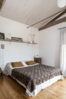 Chambre à coucher de pays avec les murs peints blancs et le plafond en bois