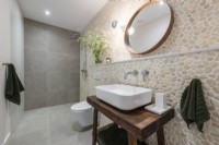 Salle de bain avec mur de pierre