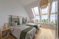 Grande chambre mansardée avec deux lits et vue sur la nature