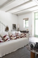 Canapé blanc recouvert de coussins dans un salon de campagne moderne