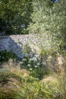 Vieux mur de pierre dans le jardin de cottage, été