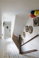Couloir peint en blanc avec vue sur escalier en bois