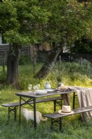 Table et bancs de jardin dans le jardin de campagne