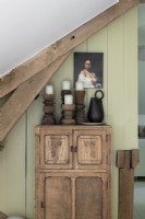 Bougeoirs en bois sculpté sur armoire rustique avec peinture de portrait