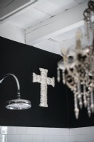 Ornement de croix argentée sur le mur noir de salle de bains