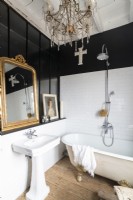 Salle de bains de campagne en noir et blanc avec lustre et miroir doré