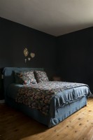 Literie florale dans une chambre peinte en noir