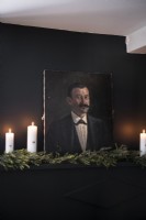 Détail du portrait classique contre un mur noir avec des bougies et des guirlandes