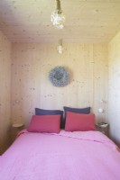 Petite chambre en bois moderne avec literie rose