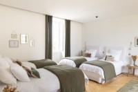Chambre verte et blanche avec quatre lits simples
