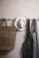 Détail de patères sur mur avec tabliers, panier et chapeau