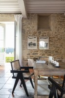 Table en bois et murs en pierres apparentes dans la salle à manger de campagne