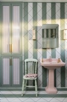 Salle de bain carrelée à rayures vertes et blanches avec vasque rose