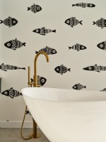 Baignoire avec robinet doré et papier peint à motifs de poissons