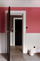 Deux portes noires et mur rose et parquet