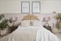 Chambre parentale avec boiseries rose pâle, tête de lit en rotin et tissus d'ameublement.
