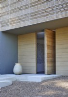 Extérieur de maison contemporaine avec porte d'entrée en bois ouverte