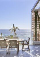 Coin repas extérieur sur terrasse avec vue sur l'océan