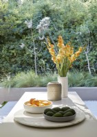 Fruits et vase de fleurs sur l'îlot de cuisine avec vue sur jardin