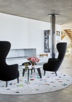 Fauteuils noirs et tapis circulaire dans le salon contemporain