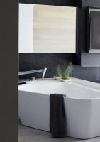Baignoire d'angle moderne dans une salle de bain monochrome